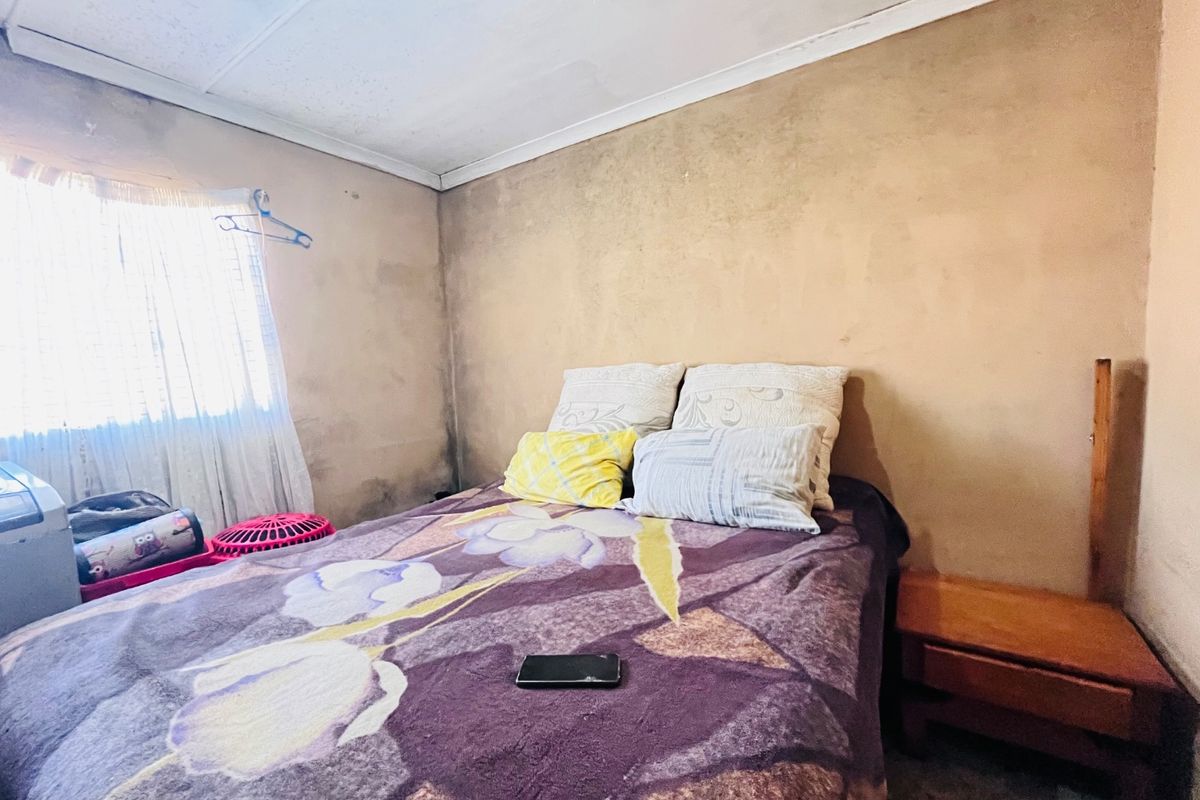 A bedroom featuring plain wall finishes and a simple cornice, requiring cosmetic updates to improve the overall condition and aesthetic appeal.