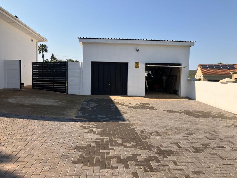 A detached double garage with a paved driveway and secure boundary walling, providing ample off-street parking space.