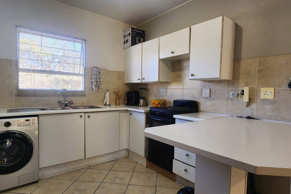 A functional kitchen featuring built-in cabinetry, a tiled backsplash, a breakfast nook, and space for a washing machine.