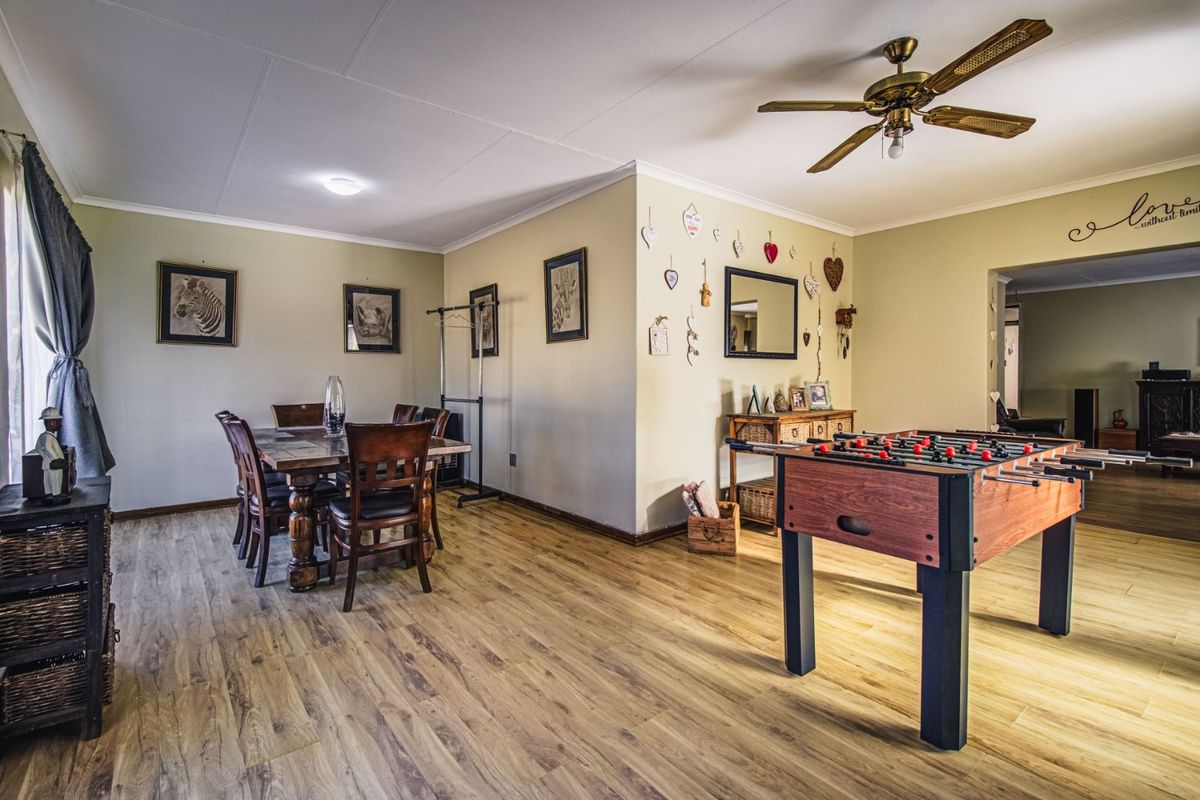 Spacious living and dining area featuring durable laminate flooring, a ceiling fan, and neutral wall tones, offering a versatile layout for family living.