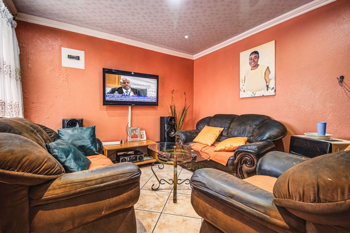A living room featuring tiled flooring and coved ceiling details, providing a functional space for relaxation.