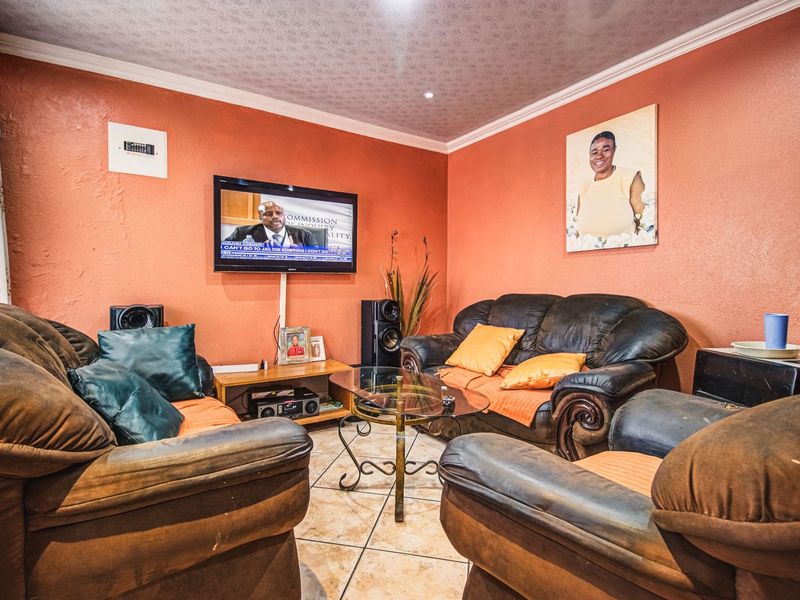 A living room featuring tiled flooring and coved ceiling details, providing a functional space for relaxation.