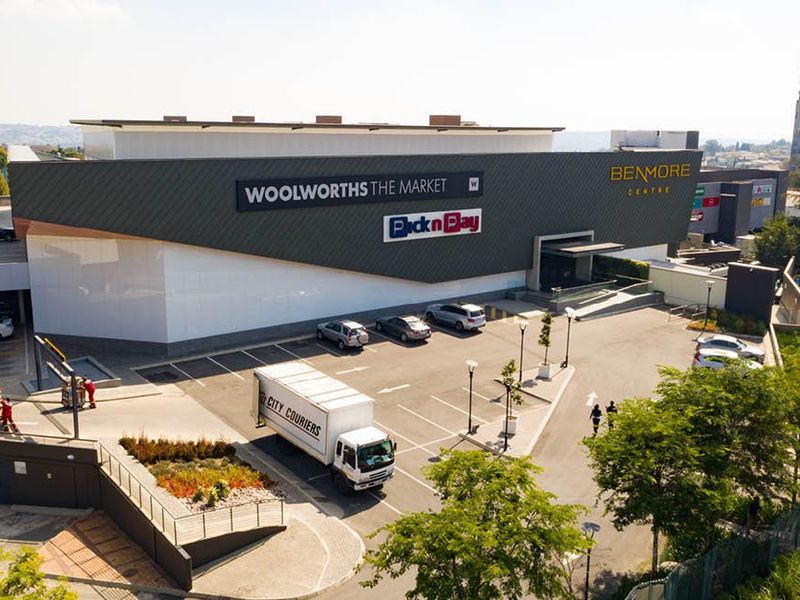 Aerial view of the Benmore Centre commercial property, featuring a large retail facade, dedicated parking area, and landscaped surroundings.