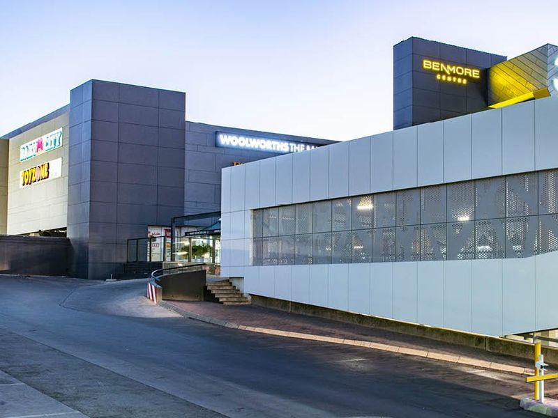 Exterior view of the Benmore Centre commercial property, featuring modern metal cladding, signage, and paved access driveway.