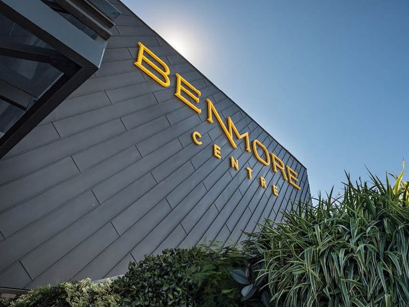 Exterior view of the Benmore Centre building featuring modern metal cladding and prominent signage, complemented by landscaped greenery.