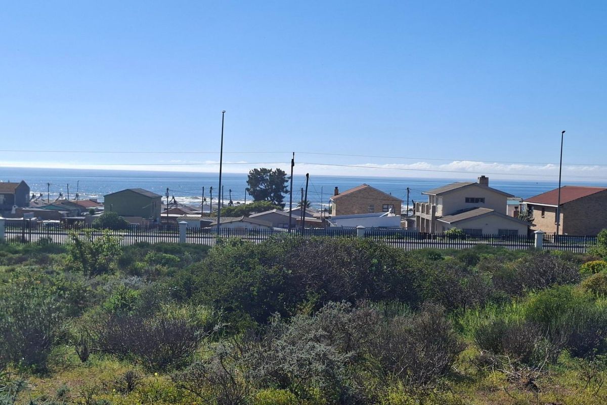 A scenic view of the ocean and surrounding residential neighborhood from the vacant land plot.