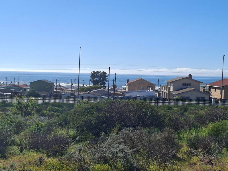 A scenic view of the ocean and surrounding residential neighborhood from the vacant land plot.