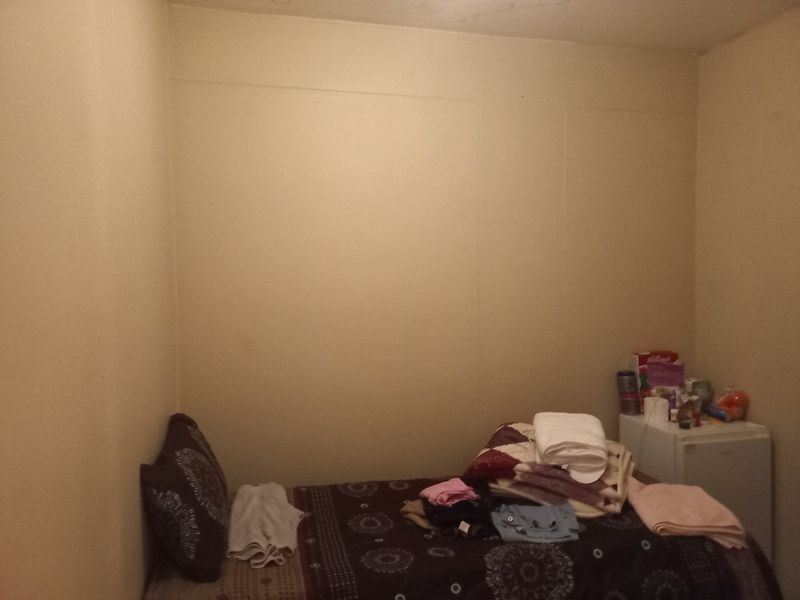 A small bedroom space with plain walls and basic finishes, suitable for renovation or restyling to enhance its appeal.