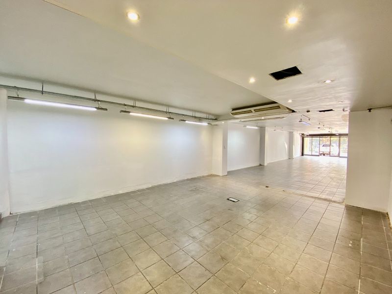 Spacious open-plan commercial unit featuring tiled flooring, recessed and track lighting, and ducted air conditioning, suitable for various retail or office configurations.