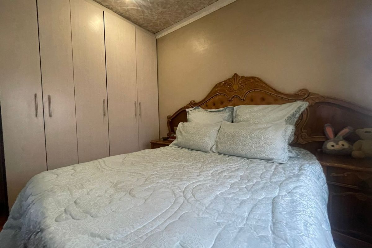 A bedroom featuring built-in cupboards and decorative ceiling detailing, providing functional storage space within a standard residential layout.