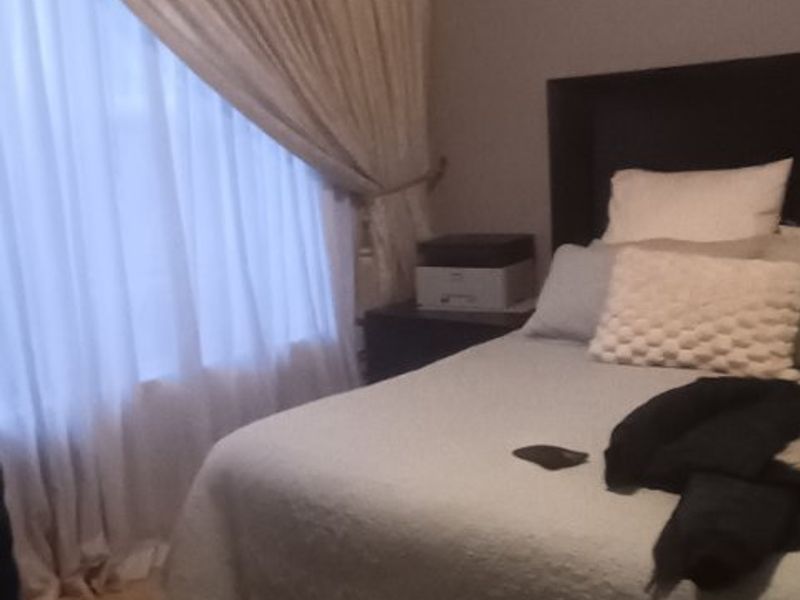 A bedroom featuring laminate flooring and decorative coving, providing a neutral base for interior design.