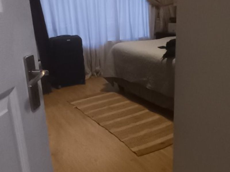 A bedroom featuring laminate flooring and coving, viewed from the doorway.