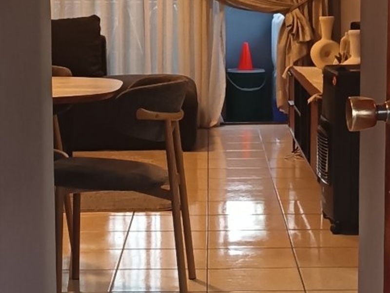 A view into a living area featuring ceramic tiled flooring and a sliding glass door leading to an outdoor space.