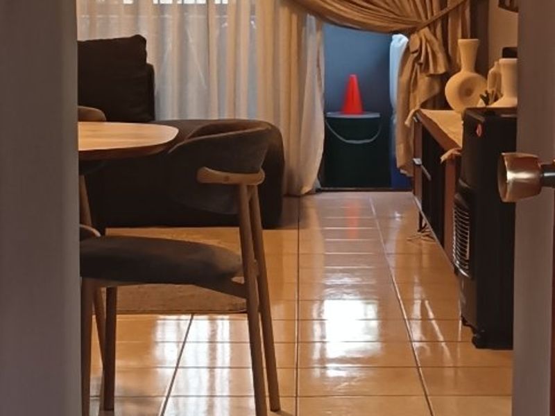 A view into a living area featuring ceramic floor tiles and a large sliding glass door leading to an outdoor space.