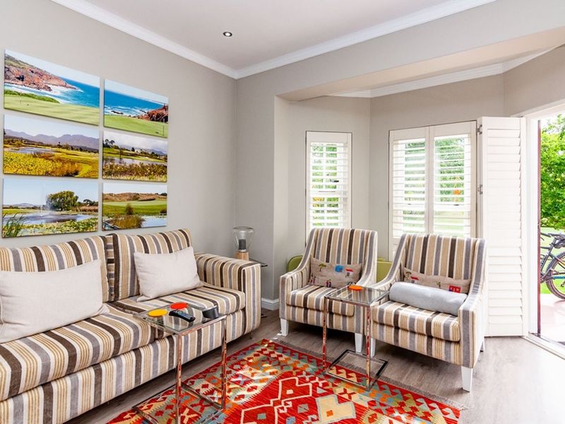 A bright and well-maintained living room featuring plantation shutters, crown molding, and direct access to the outdoor area.