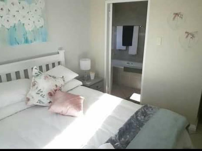 A bedroom featuring tiled flooring and an adjoining en-suite bathroom, providing a functional and private living space.
