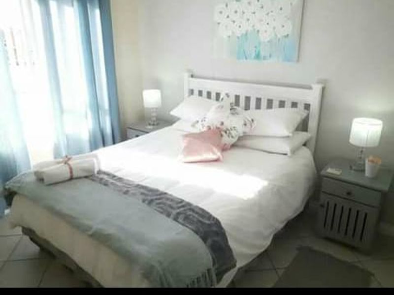 A cozy bedroom featuring tiled flooring and natural light from the window, providing a comfortable and functional sleeping space.