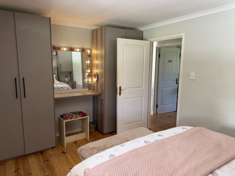 A well-maintained bedroom featuring built-in wardrobes, timber flooring, and neutral wall finishes, providing a clean and functional living space.