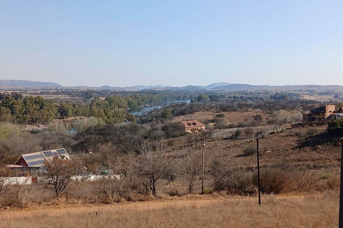 A scenic elevated view overlooking the surrounding landscape, river, and distant hills, showcasing the natural setting of the vacant residential land.