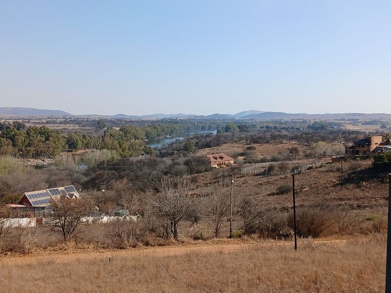 A scenic elevated view overlooking the surrounding landscape, river, and distant hills, showcasing the natural setting of the vacant residential land.
