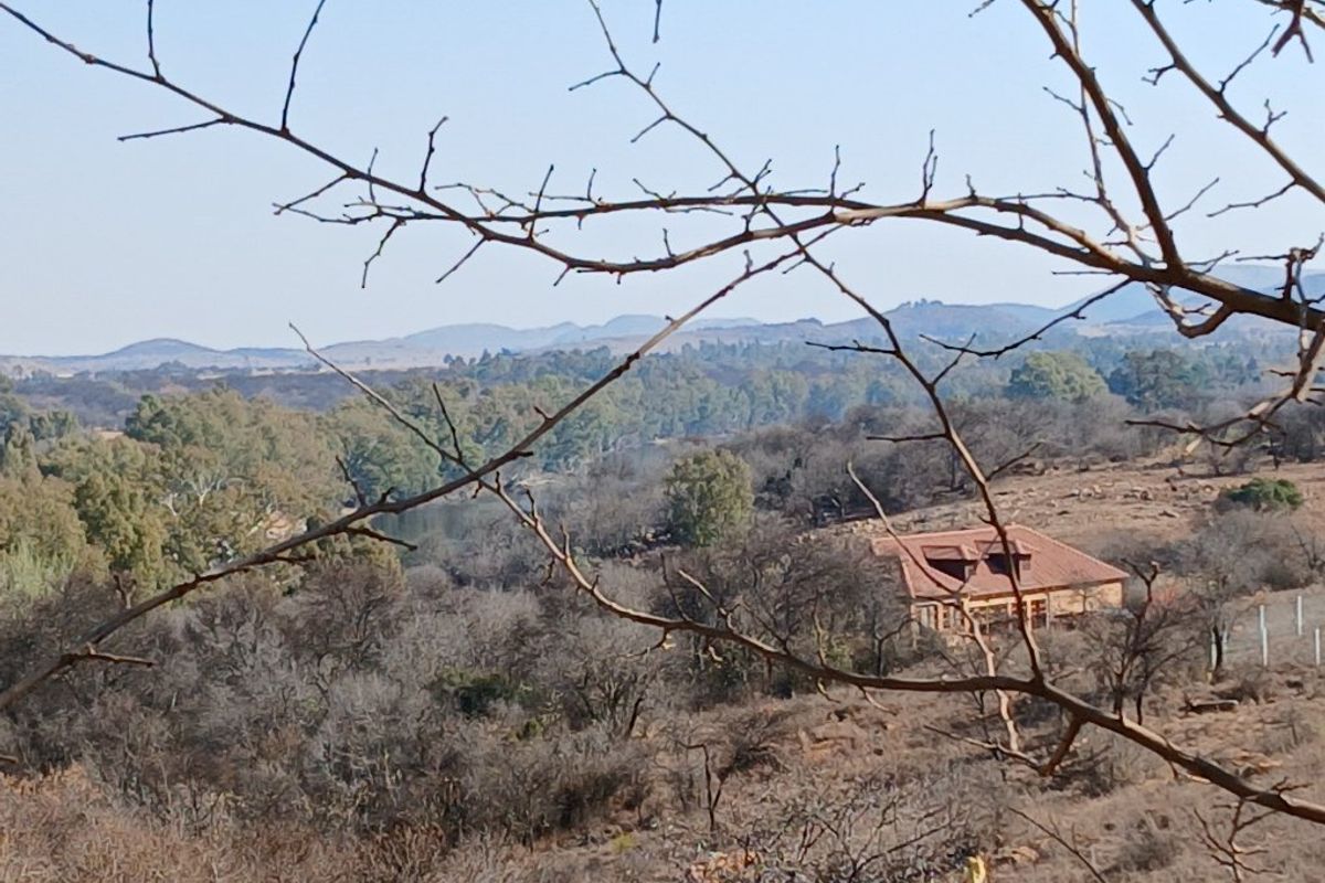 A scenic elevated view of the surrounding landscape and natural vegetation, showcasing the rural setting of the property.
