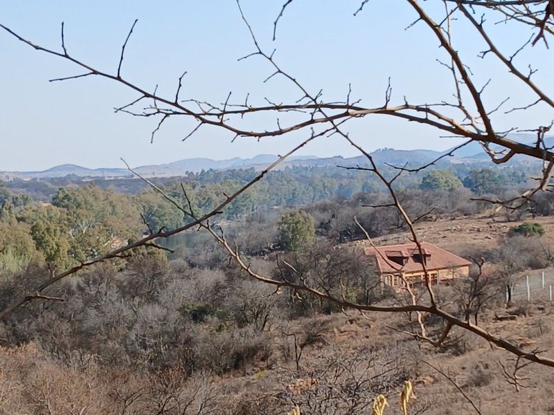 A scenic elevated view of the surrounding landscape and natural vegetation, showcasing the rural setting of the property.