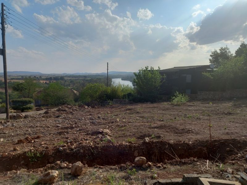 A scenic view overlooking a river and surrounding landscape from a vacant residential plot.
