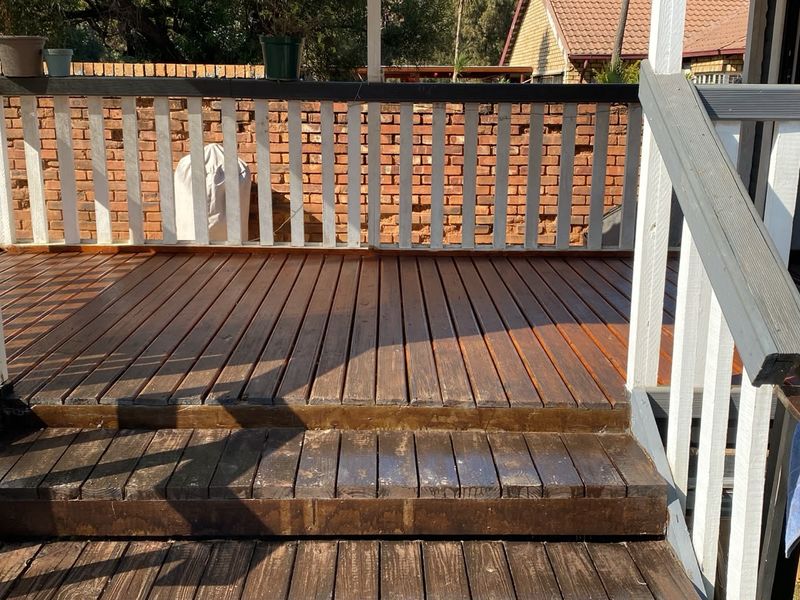 An outdoor timber deck featuring a wooden balustrade and staircase, providing a functional space for outdoor living and entertainment.