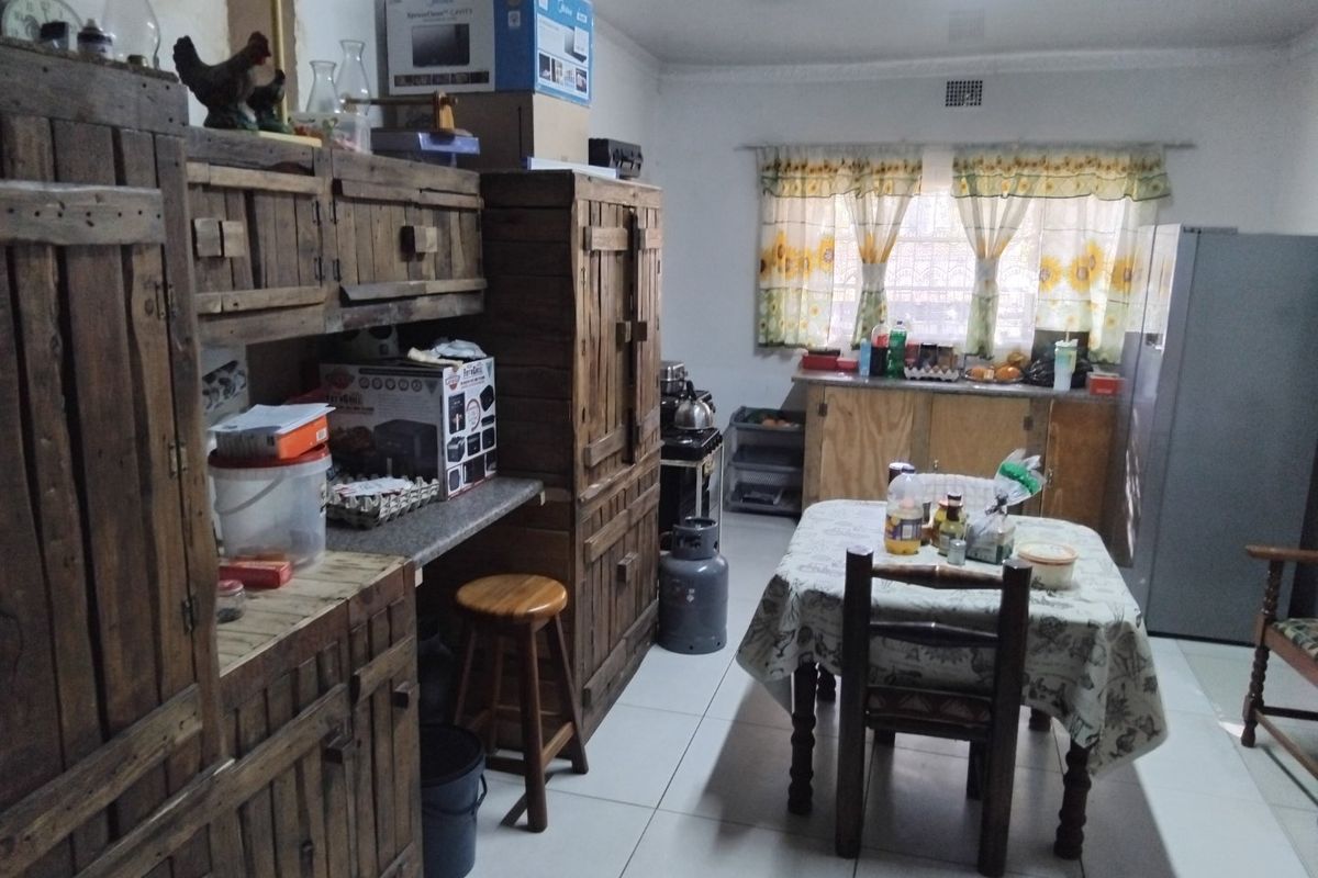 A functional kitchen space featuring tiled flooring, built-in wooden cabinetry, and a gas stove, offering potential for modernization and aesthetic updates.