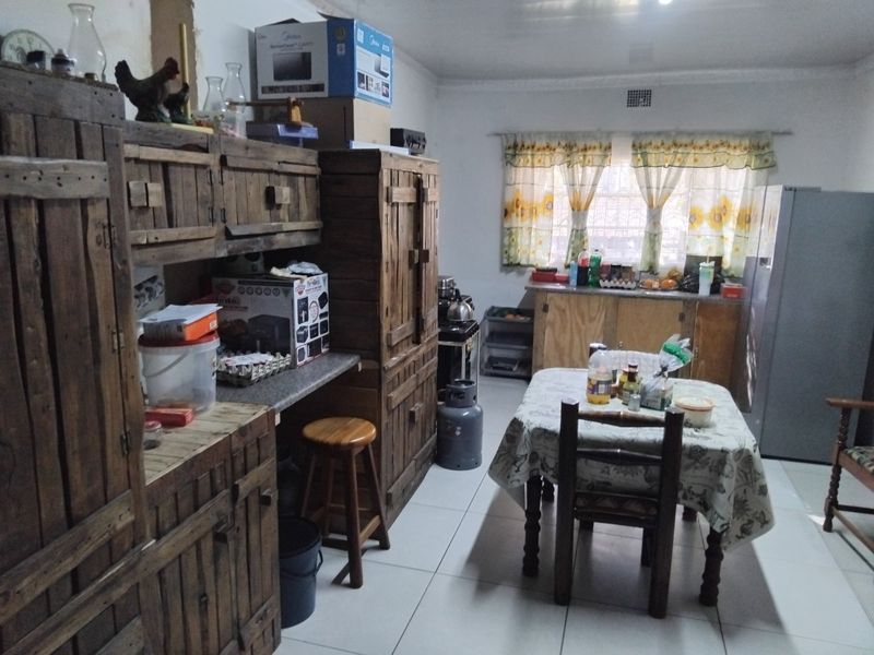 A functional kitchen space featuring tiled flooring, built-in wooden cabinetry, and a gas stove, offering potential for modernization and aesthetic updates.