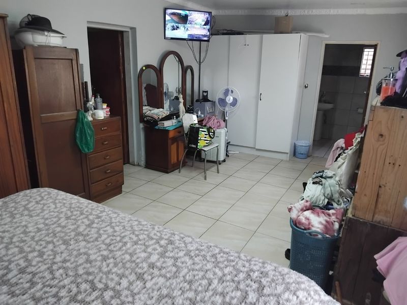 A bedroom featuring tiled flooring and built-in cupboards, providing functional storage space.