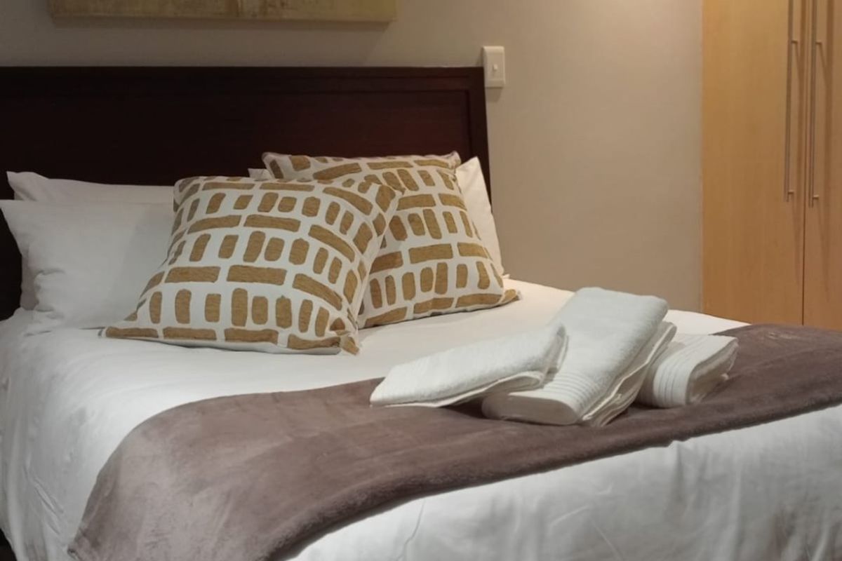 A well-maintained bedroom featuring a built-in wardrobe and recessed ceiling lighting, providing a clean and functional living space.