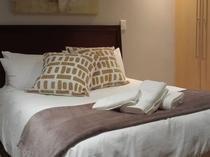 A well-maintained bedroom featuring a built-in wardrobe and recessed ceiling lighting, providing a clean and functional living space.