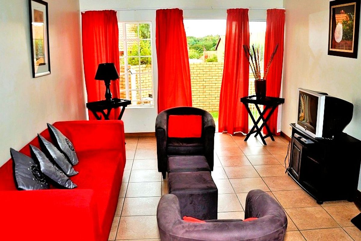 A living room featuring tiled flooring and a sliding glass door providing access to the exterior.