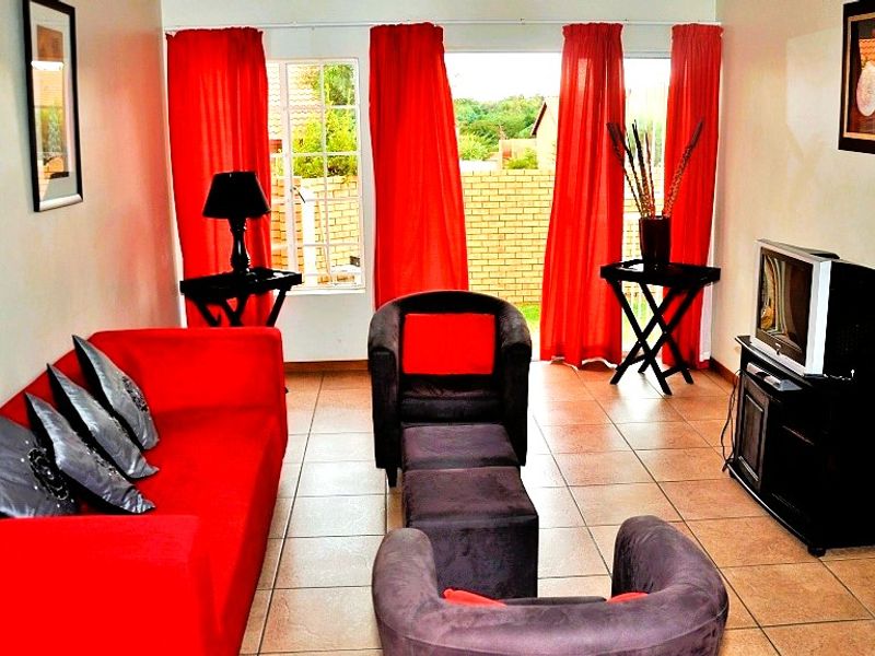 A living room featuring tiled flooring and a sliding glass door providing access to the exterior.