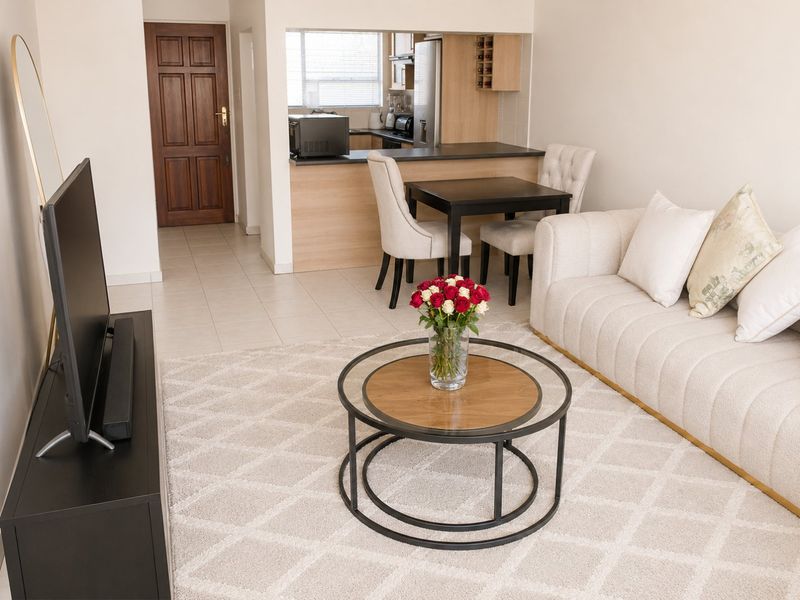 Open plan living area featuring tiled floors, a breakfast counter, and a functional kitchen layout with built-in cabinetry.