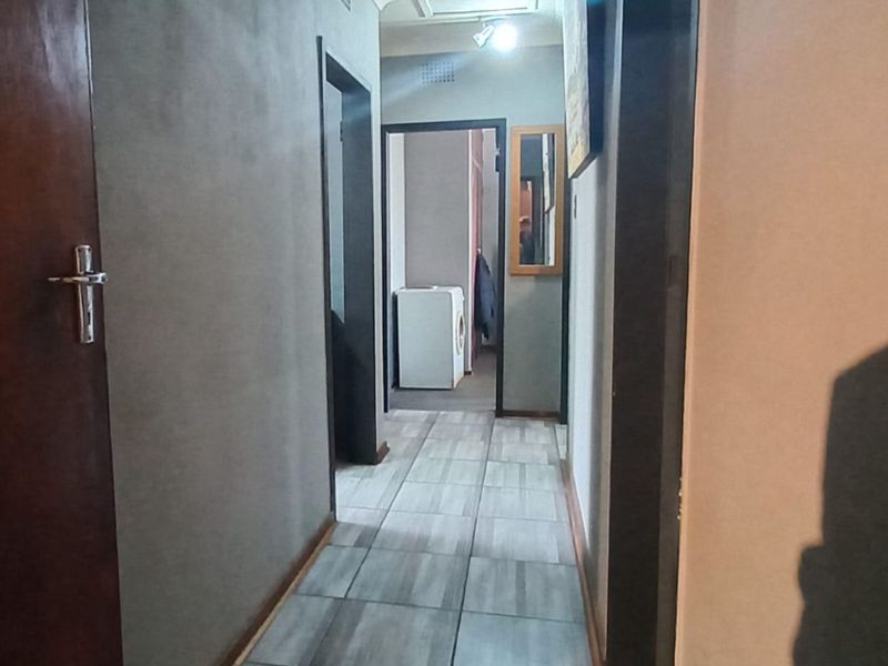 A functional interior hallway featuring tiled flooring and access to multiple rooms, providing a central circulation space within the home.