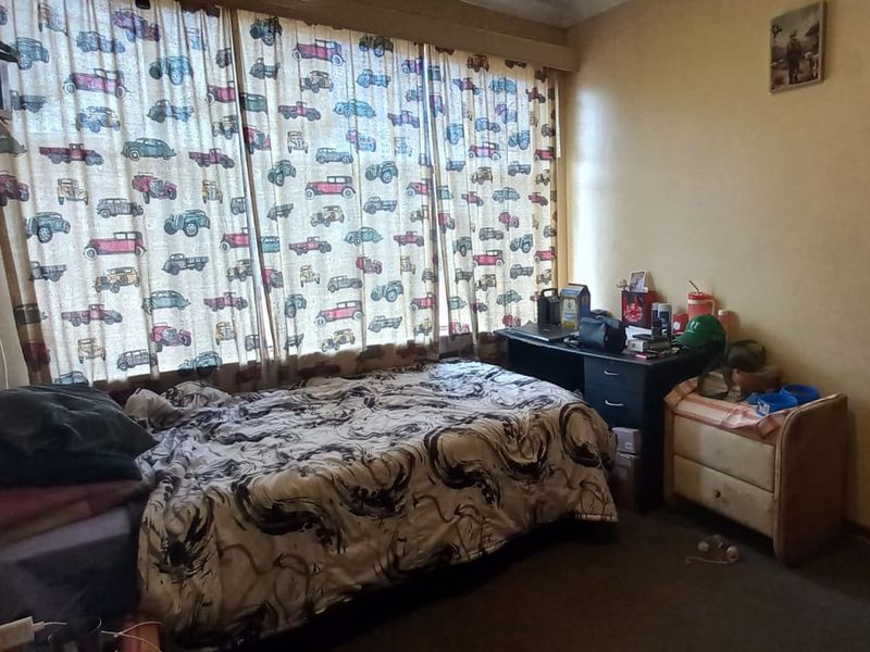 A bedroom featuring a large window with curtain rails, providing natural light to the space.