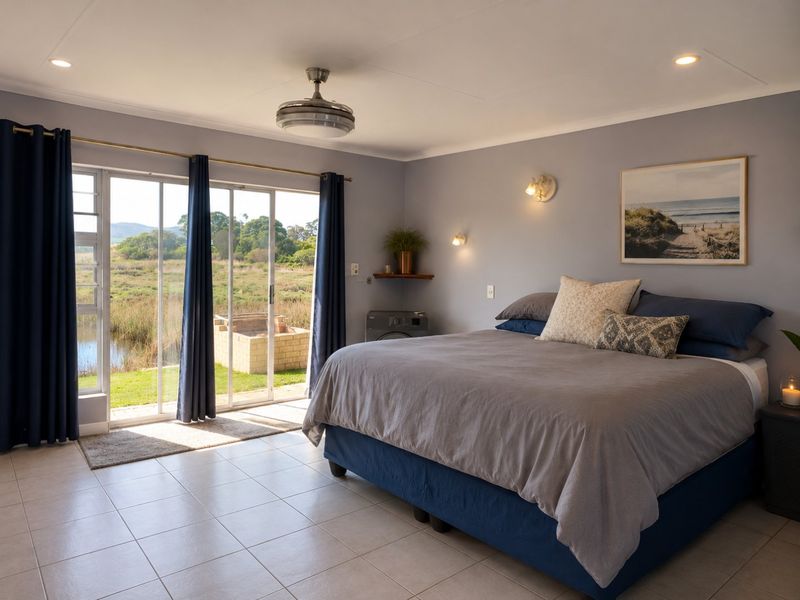 Spacious bedroom featuring tiled flooring, ceiling fan, and large sliding glass doors providing natural light and direct access to the outdoor area.
