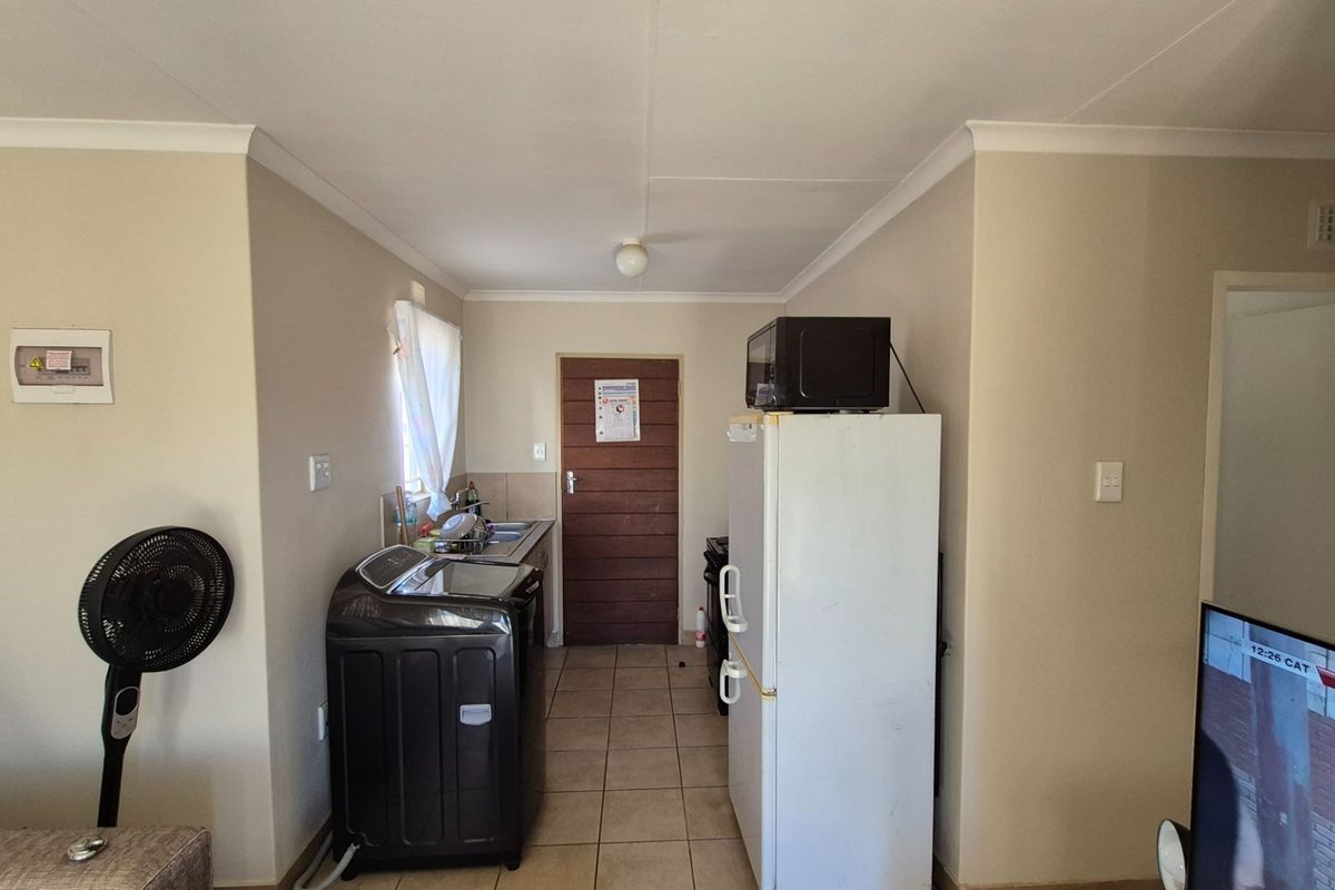 A functional kitchen area featuring tiled flooring, a built-in sink, and neutral wall finishes, providing a practical space for daily culinary tasks.