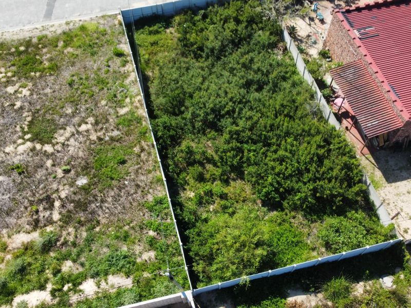 Aerial view of a vacant residential plot featuring established perimeter fencing and significant overgrown vegetation, ready for clearing and development.