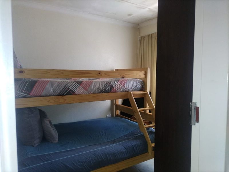 A bedroom featuring a bunk bed with visible ceiling water staining, indicating potential maintenance requirements for the ceiling finish.