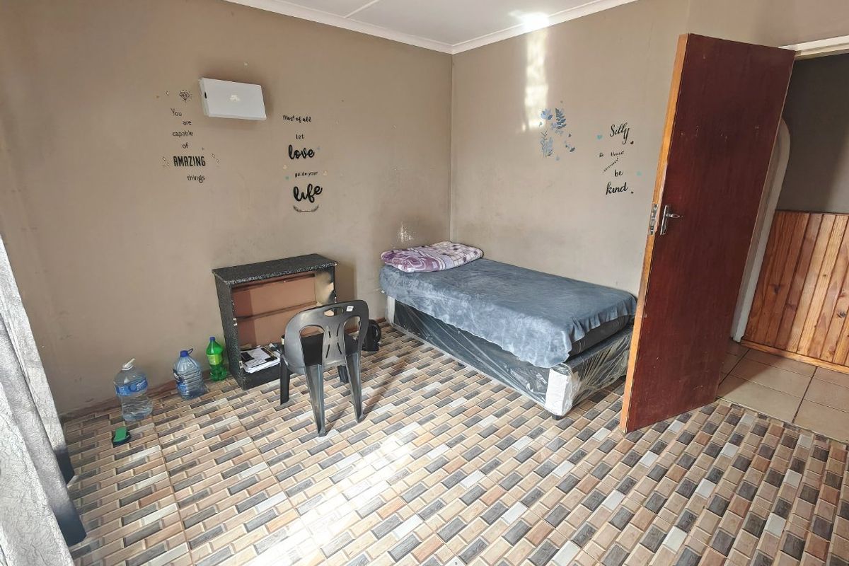 A bedroom featuring tiled flooring and a timber door, requiring cosmetic updates to the wall finishes to improve the overall aesthetic.