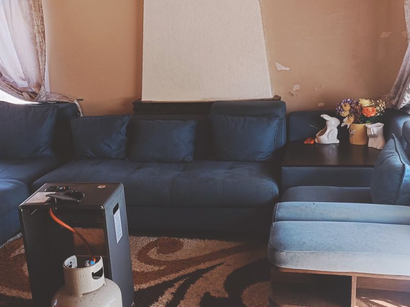 A living room featuring a central fireplace surround and wall surfaces in need of cosmetic repair and repainting.