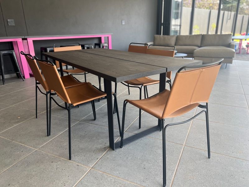 A spacious covered patio area featuring large format floor tiles and a modern, open-air design suitable for outdoor dining and relaxation.