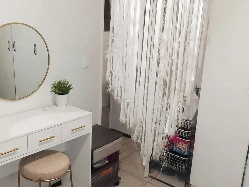 A bedroom featuring built-in wardrobes and tiled flooring, providing a functional storage space.
