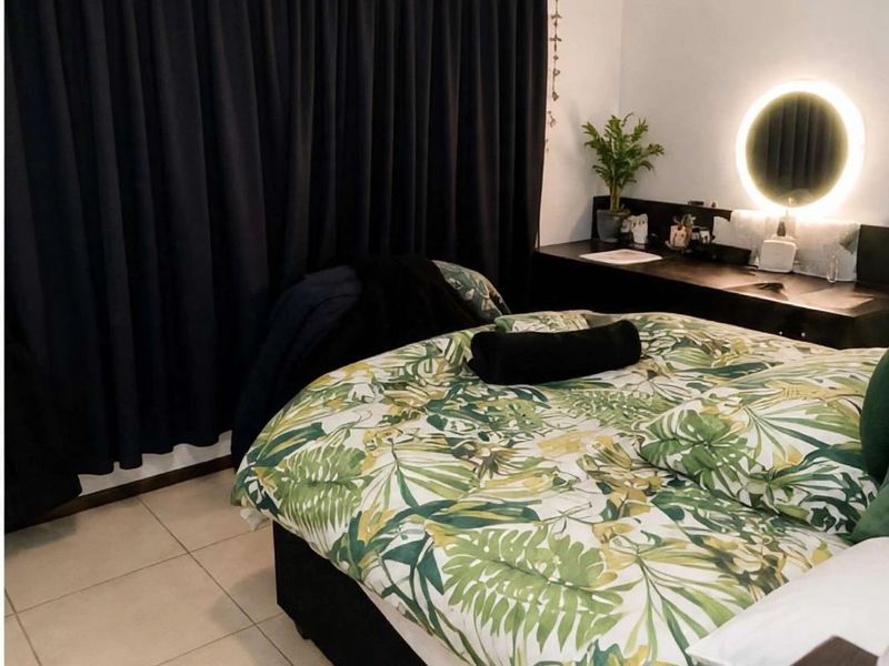 A bedroom featuring tiled flooring and a built-in vanity unit with integrated circular mirror lighting.