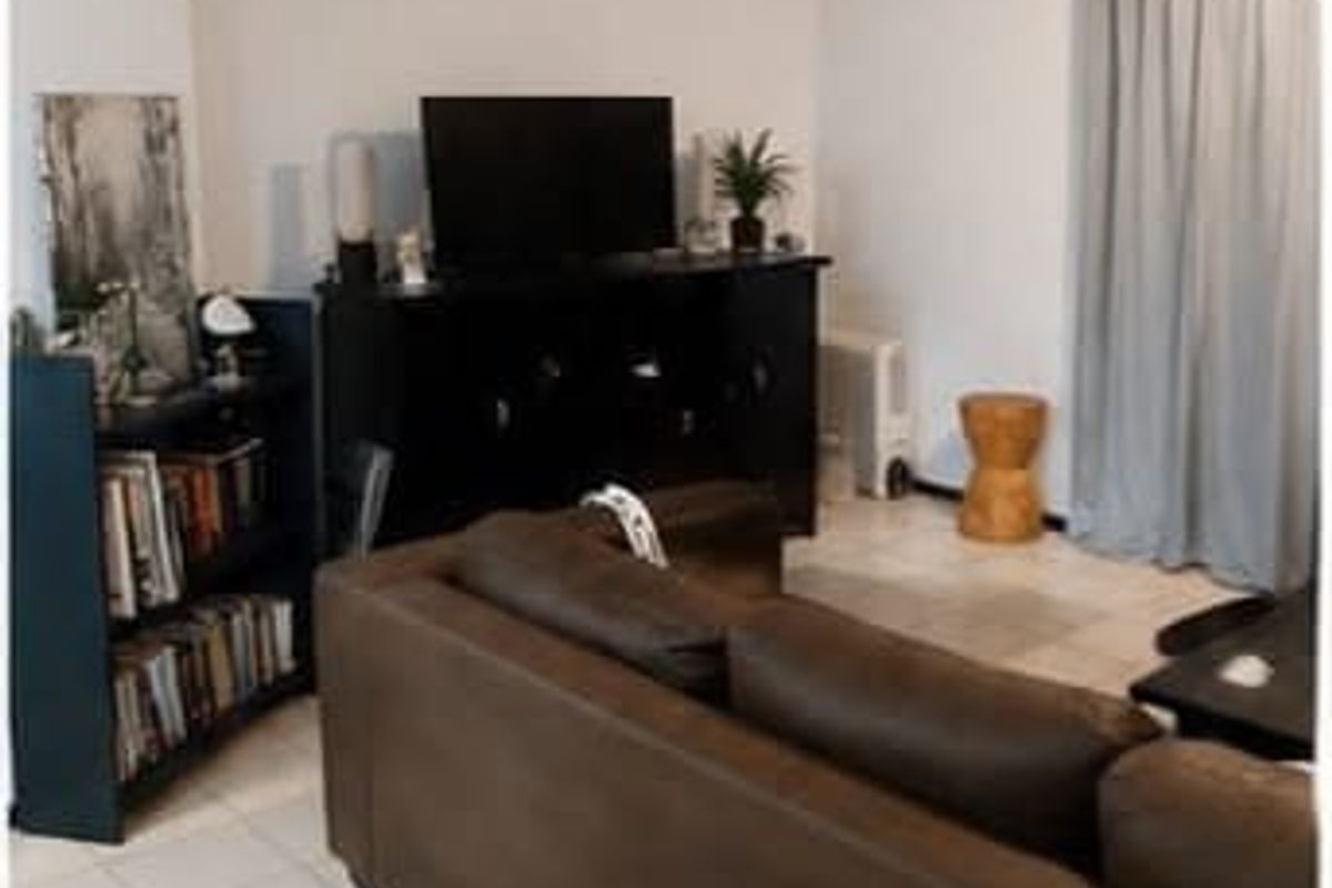 A living room area featuring tiled flooring and neutral wall finishes, providing a functional space for relaxation.