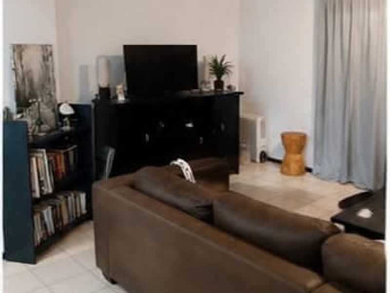 A living room area featuring tiled flooring and neutral wall finishes, providing a functional space for relaxation.