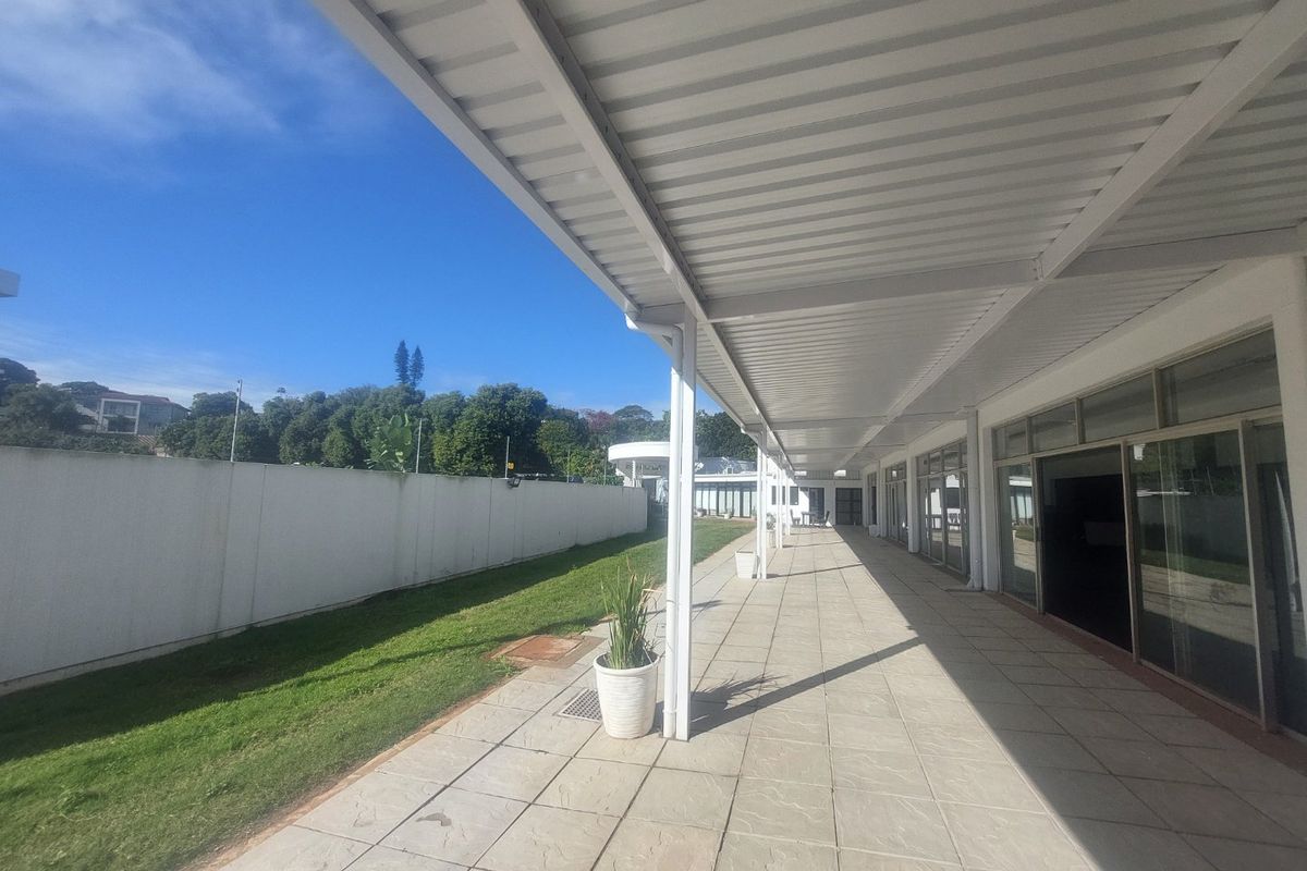 Spacious covered patio area with tiled flooring, metal roofing, and large sliding glass doors providing access to the interior.